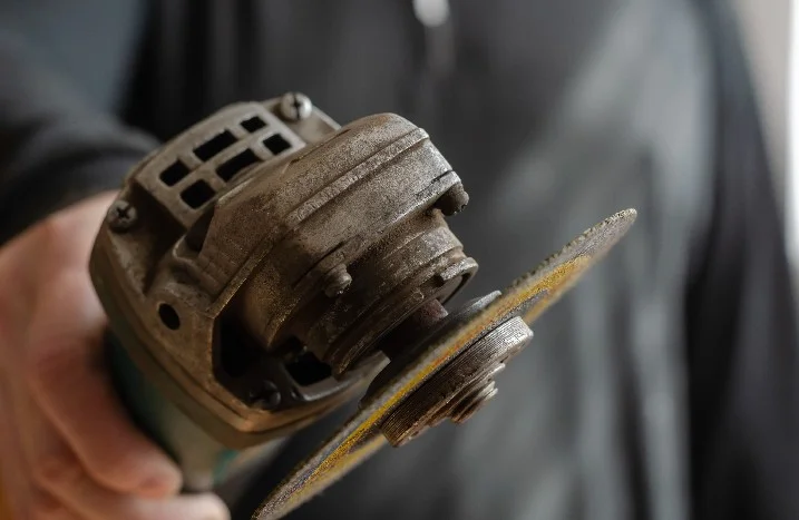 Person hält einen Winkelschleifer